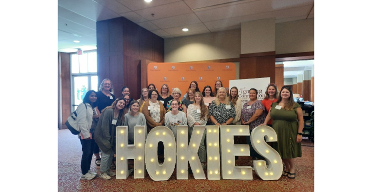 group picture in front a sign for the Hokies